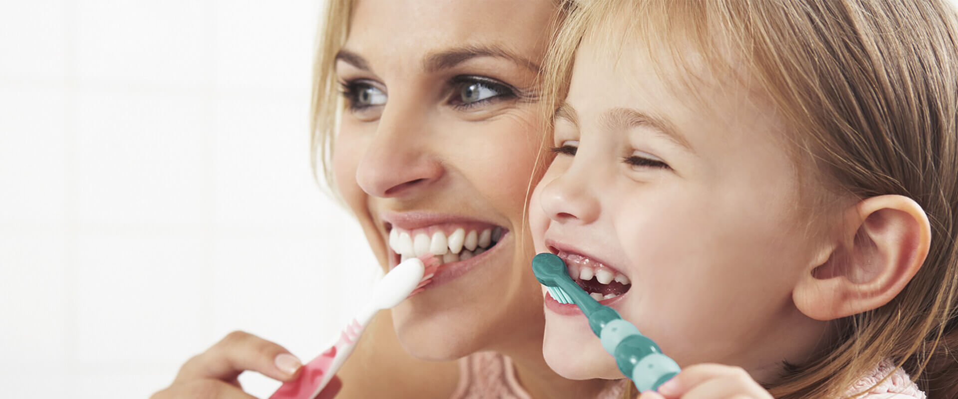 Frau und Mädchen beim gemeinsamen Zähneputzen